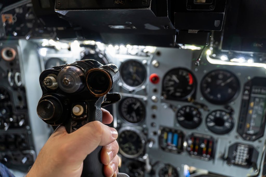 Pilot gripping a controller in a helicopter using fluorescent pigments