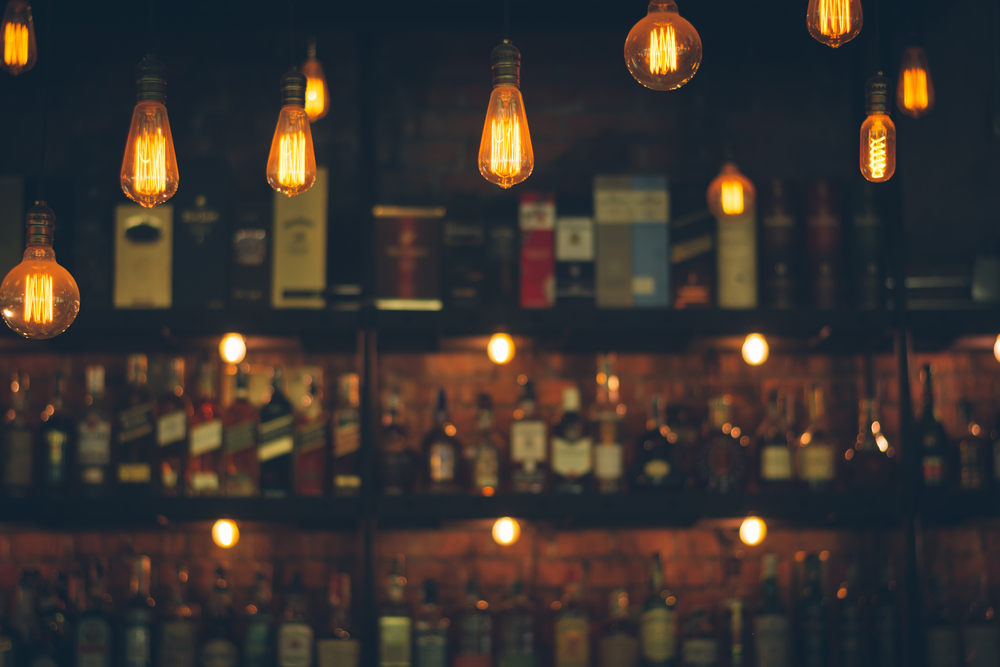 Soft focus of luxury alcohol bottles behind a bar